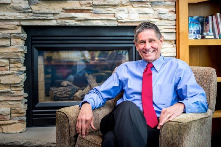 Dr. Michael Wilcox sitting next to a fireplace