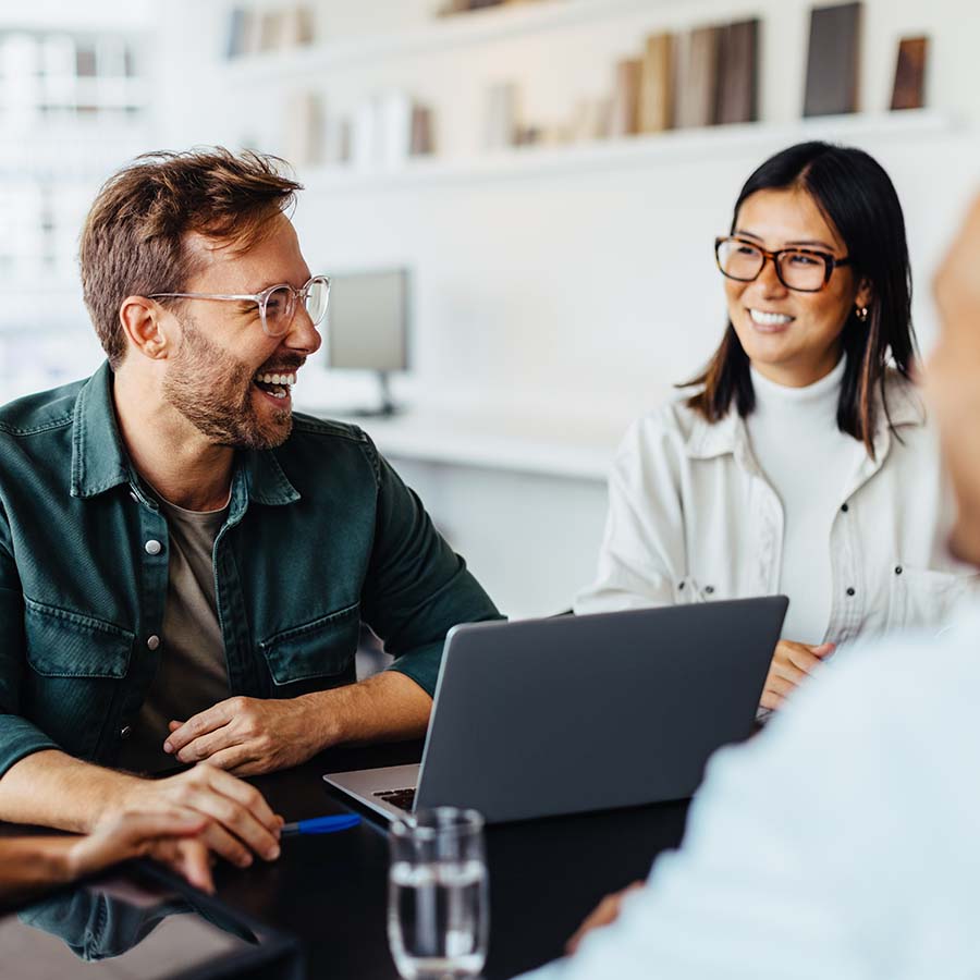 Two people at a laptop in an office