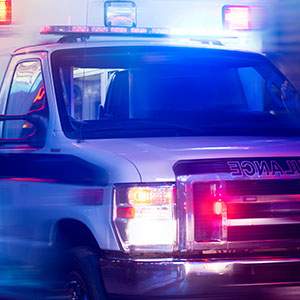 Ambulance with flashing lights on a city street.