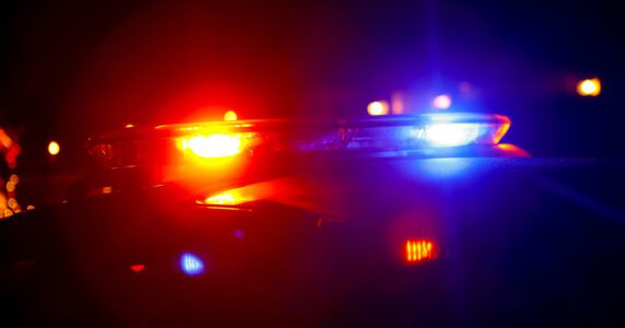 Police car with flashing red and blue lights at night.
