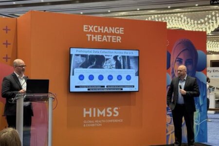 Two speakers present at the HIMSS Global Health Conference's Exchange Theater. A screen displays a presentation titled "Prehospital Data Collection Across the U.S.