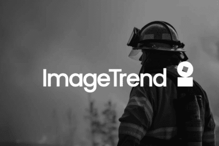 A firefighter in protective gear stands outdoors with smoke in the background; the ImageTrend logo is overlaid on the image.