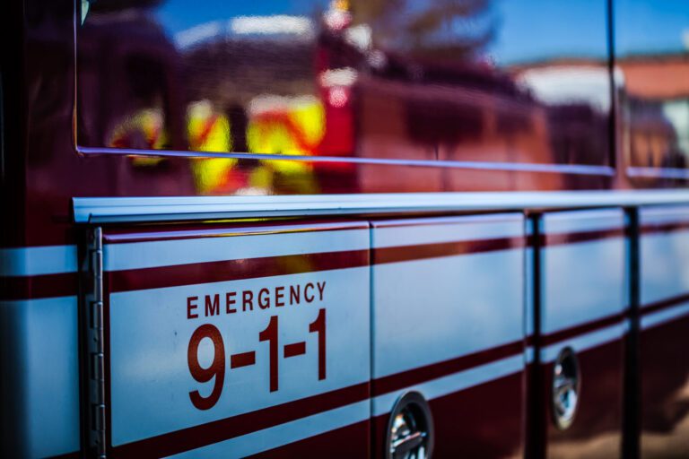 Close-up of an emergency vehicle with "Emergency 9-1-1" text displayed on the side.