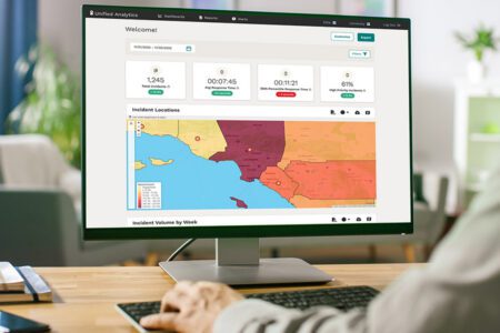 Person using a desktop computer displaying a data analytics dashboard with incident statistics and a color-coded map of Southern California.