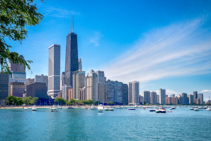 Chicago city skyline with high-rise buildings and boats on Lake Michigan under a clear blue sky.